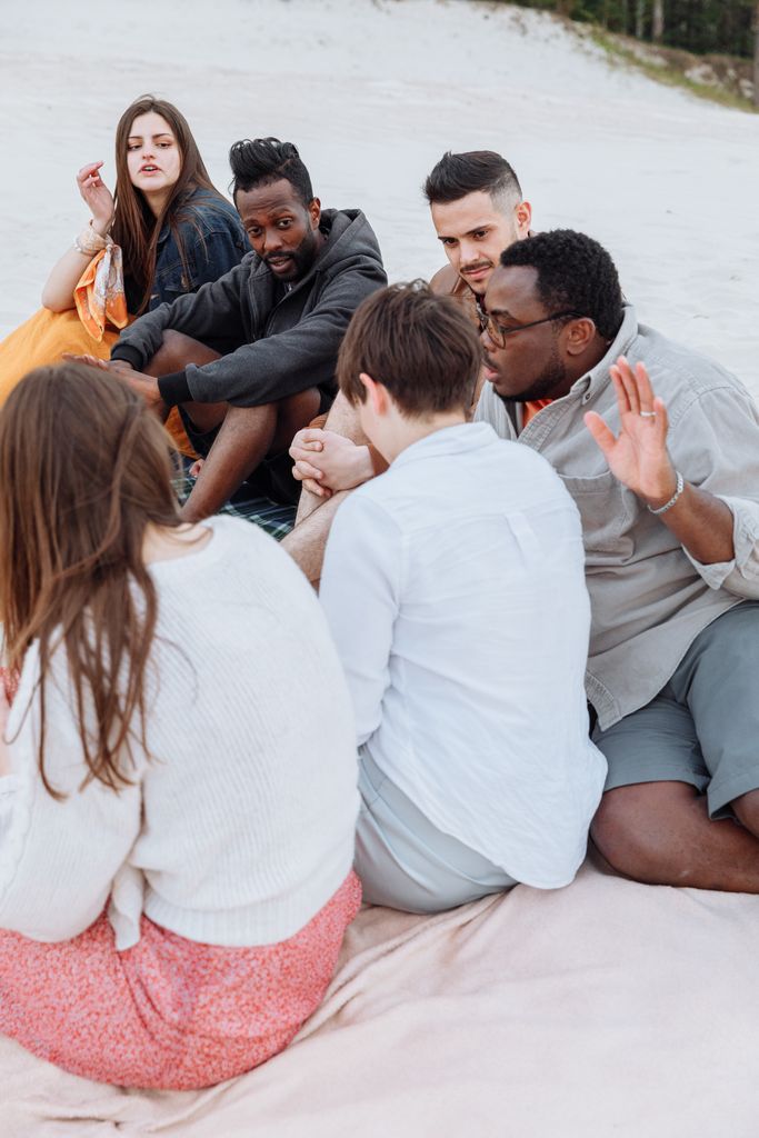 A diverse group of adults enjoying a relaxing day on a sandy beach.
